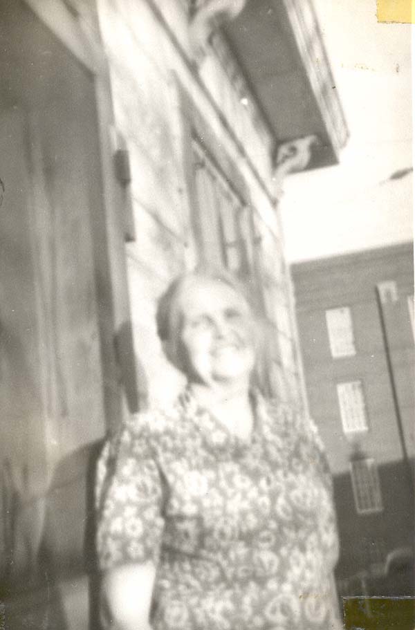 Bertha in front of a house, smiling